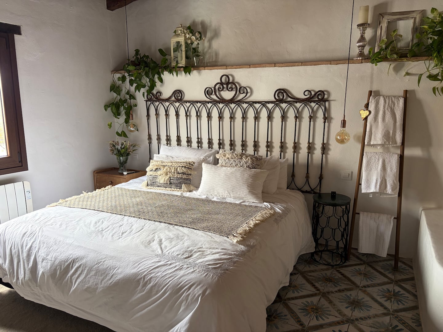 La cama de Eternal Rural Jimena con su cabecero de hierro en forma de corazón